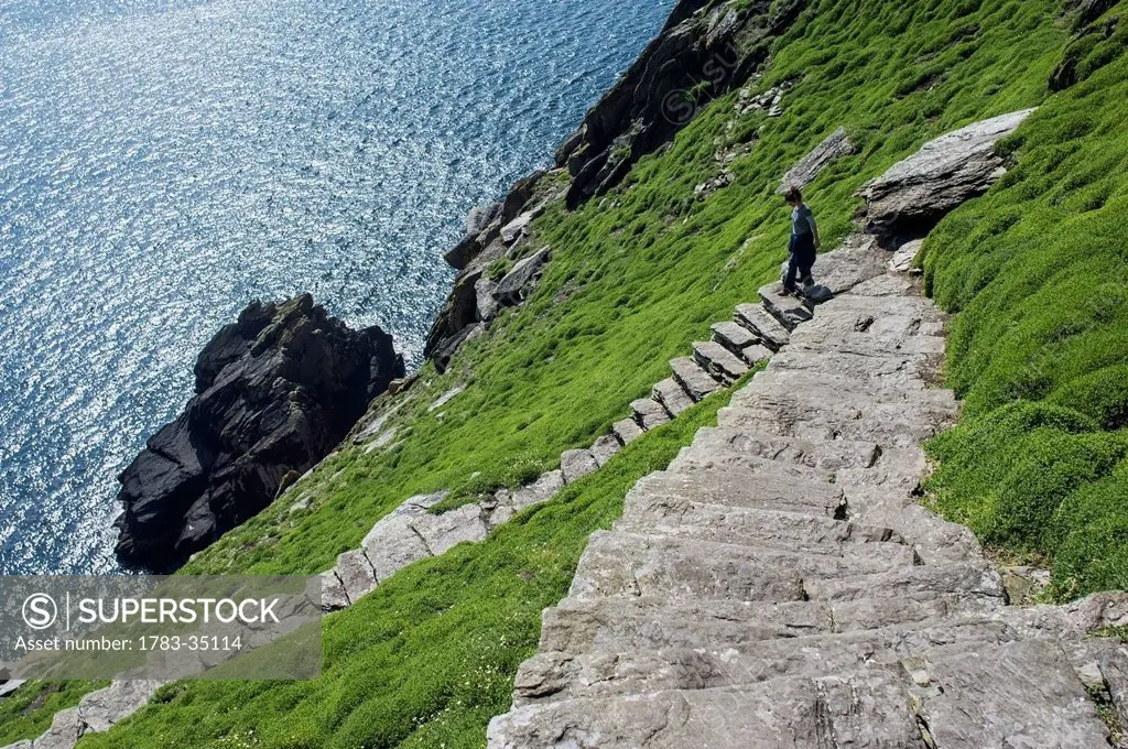 Uk, Ireland, County Kerry, Hiker On Footpath Climbing Up Skellig Michael; Skellig Islands