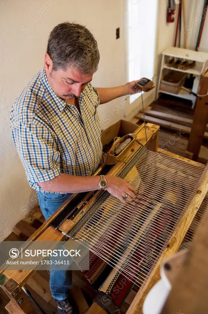 Man Working On Loom Demonstration At Ortega's Weaving Shop, New Mexico, Usa