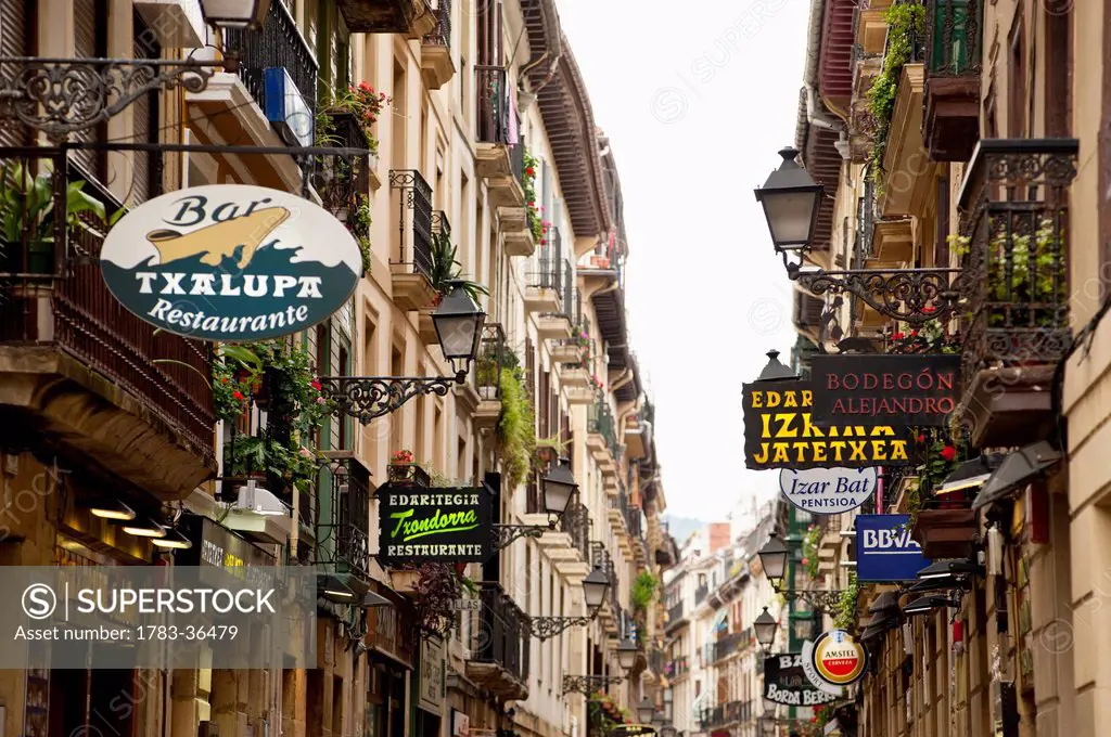 Narrow Street With Shop Signs In The Old Quarter, San Sebastian, Basque Country, Spain