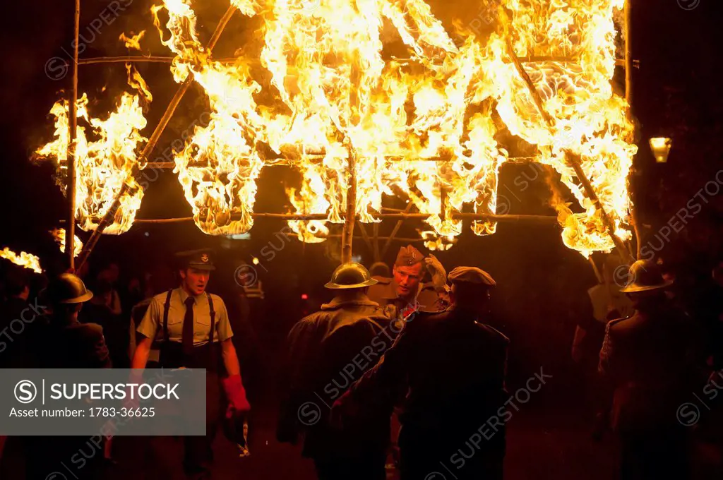 People From East Hoathly & Halland Carnival Society Carrying Large Burning Banner Through East Hoathly On Bonfire Night, East Sussex, Uk