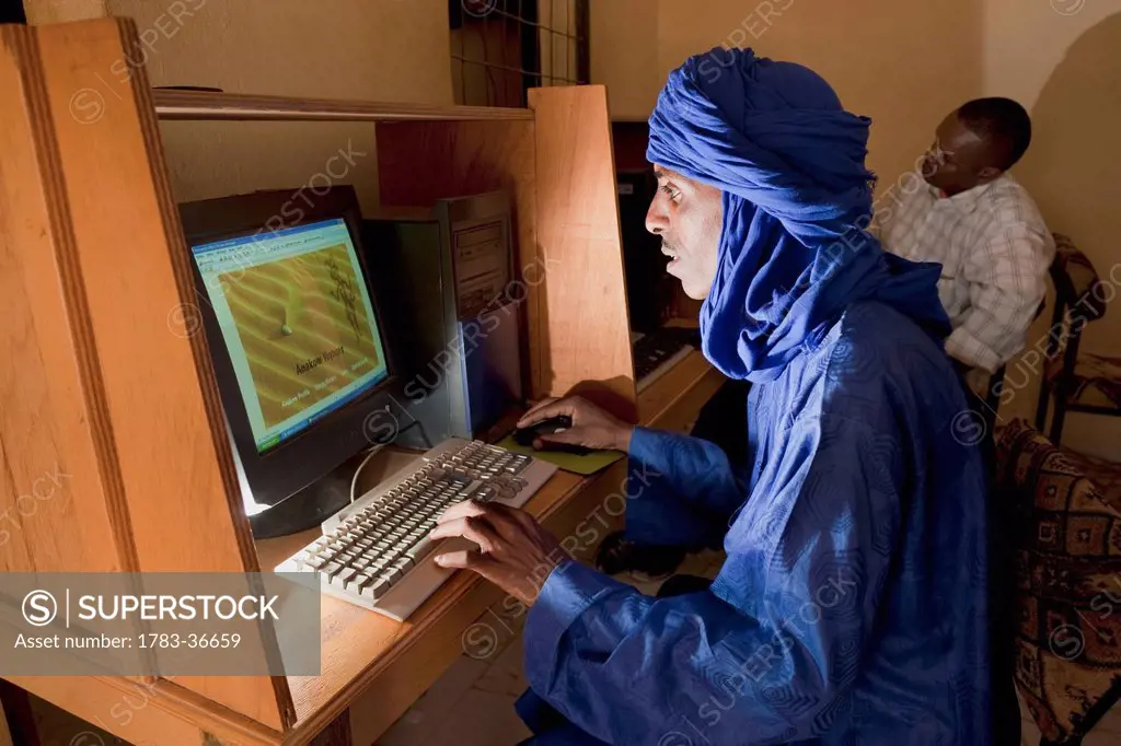 Niger, Sahara Desert, Agadez Region, Tuareg Man Surfing Net At Internet Cafe; Agadez