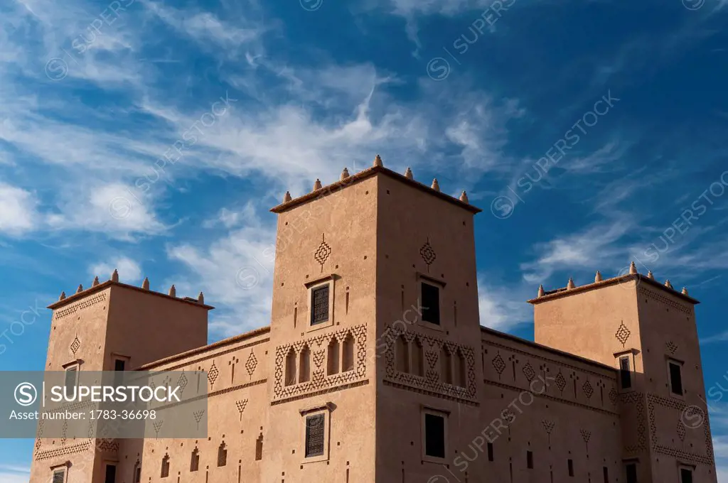 Morocco, Main kasbah of Dar Ahlam Hotel with cirrus clouds behind; Skoura