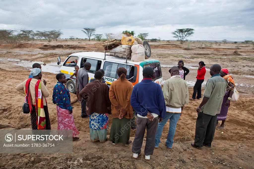 Kenya, View of people standing next to car; North Turkana