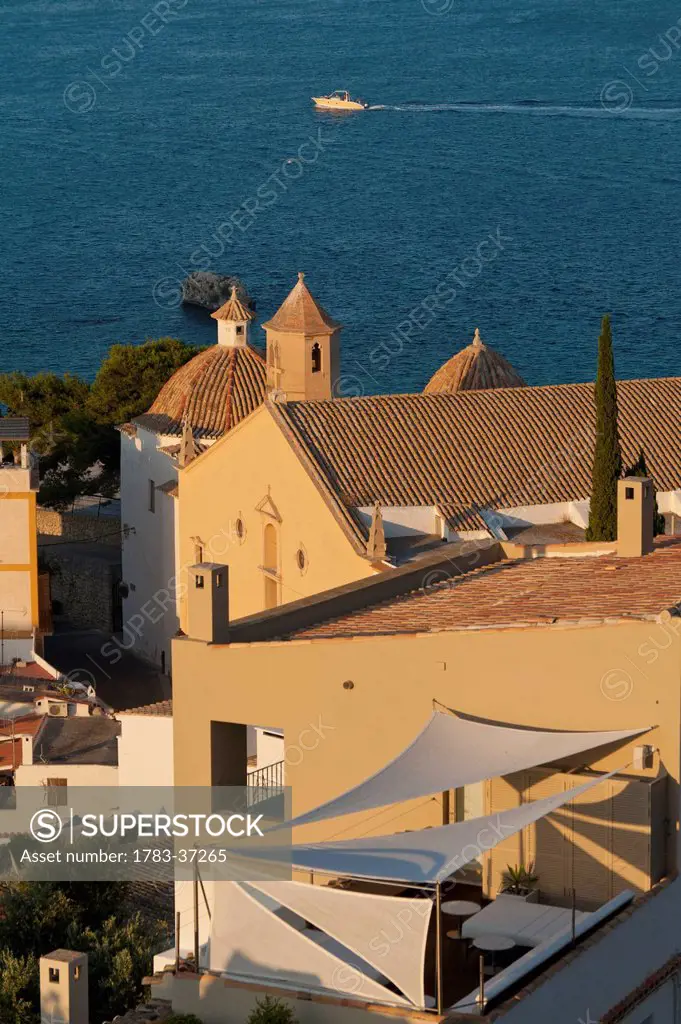 Looking over shaded roof terrace and Santo Domingo Church in Dalt Vila; Ibiza Town, Ibiza, Spain