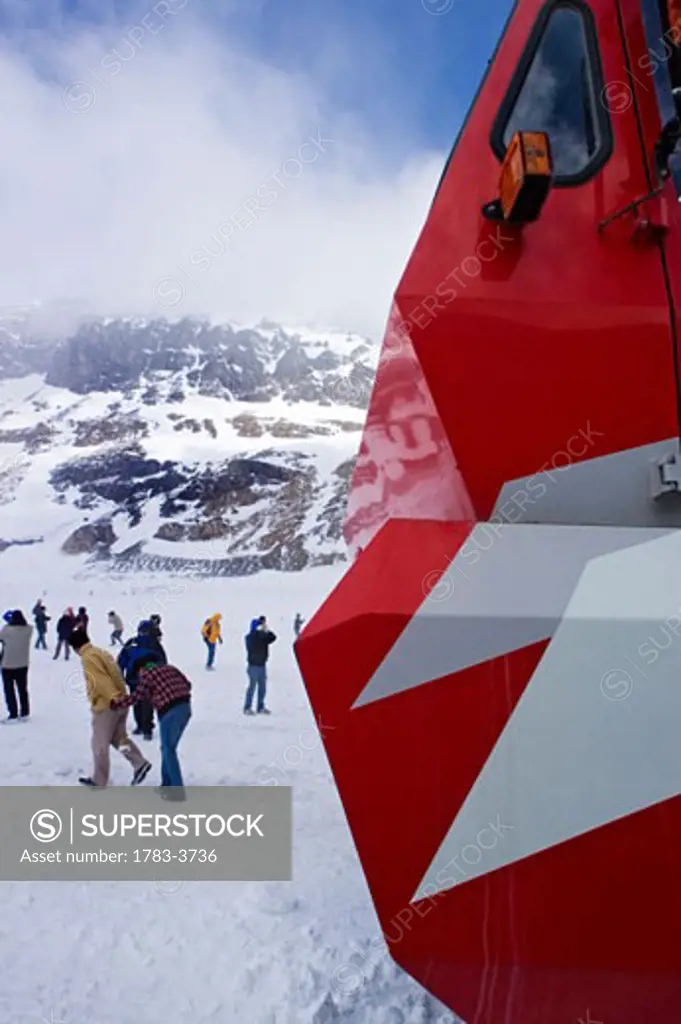 Part of snowcoach, people walking on icefield, Alberta, Canada