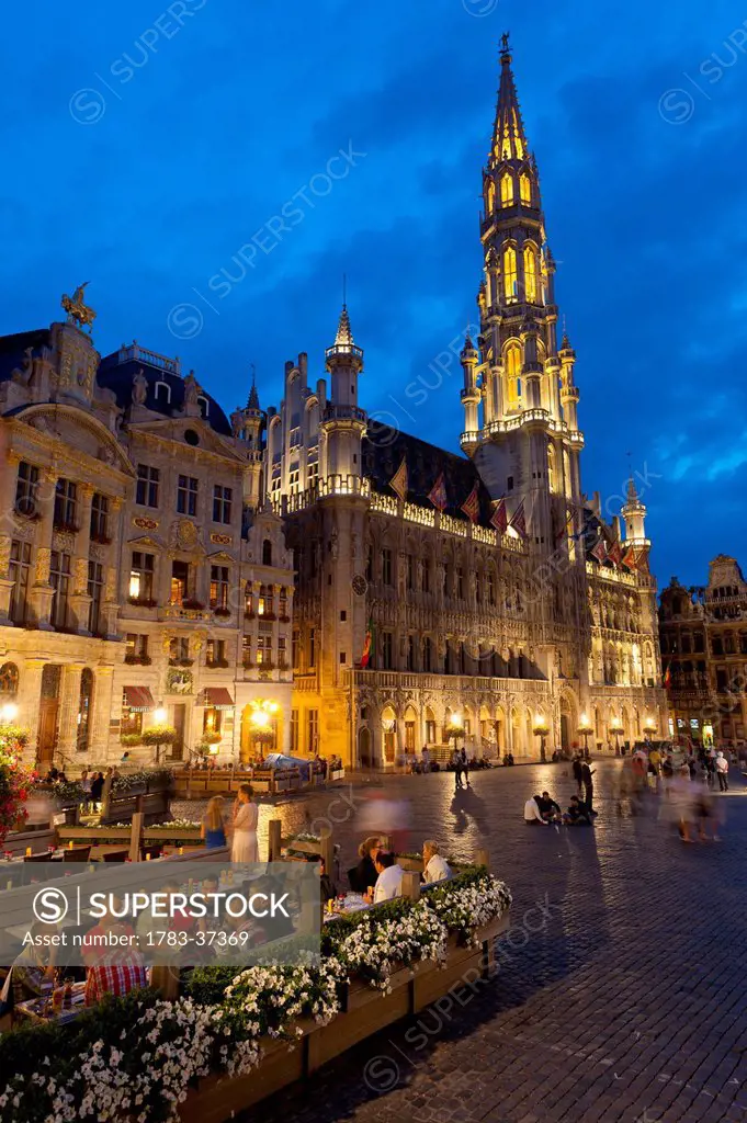 People at restaurant tables at dusk in Grand Place; Brussels, Belgium