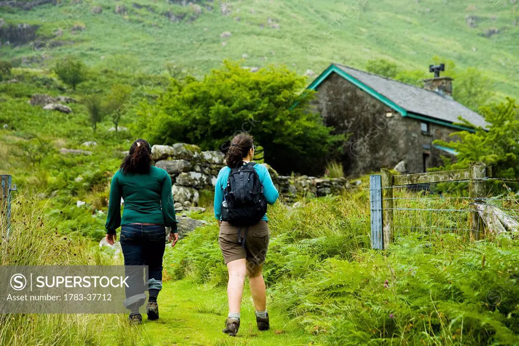 Walking the trails and footpaths of Snowdonia, approaching small isolated cottage on hillside; Nantgwynant, Snowdonia National Park, North Wales, UK