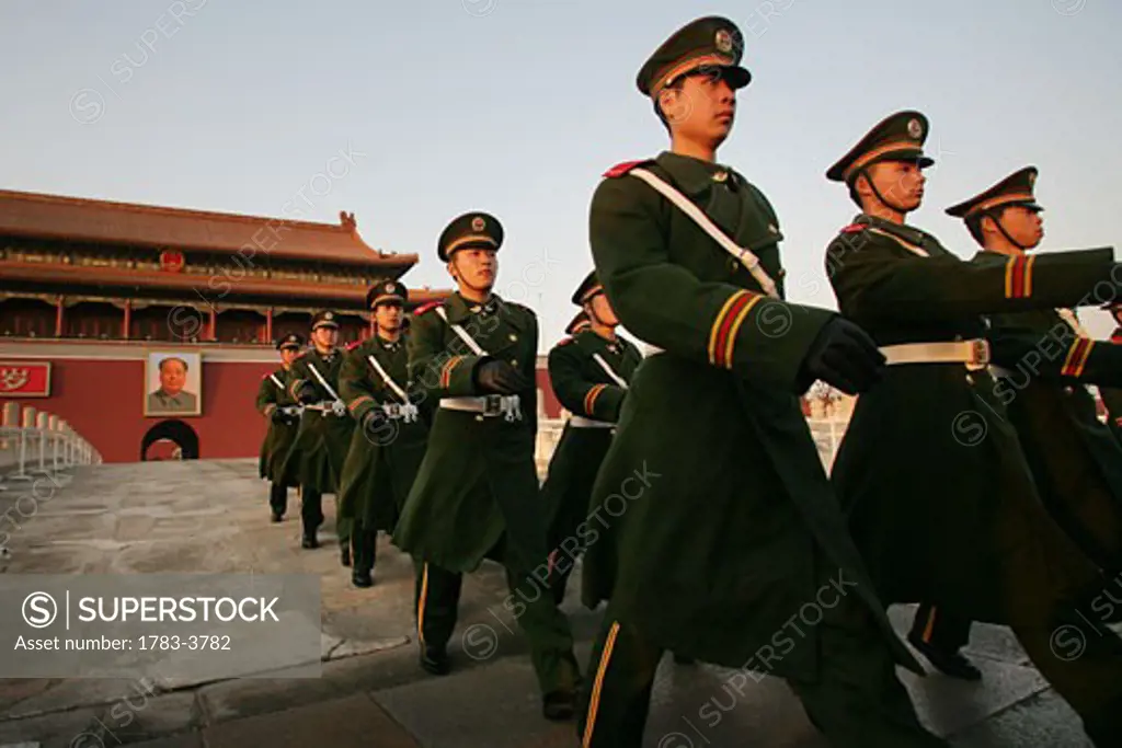 Beneath the portrait of Chairman Mao Zedong, Chinese soldiers keep guard outside the Forbidden City, Tiananmen Square, Beijing, China
