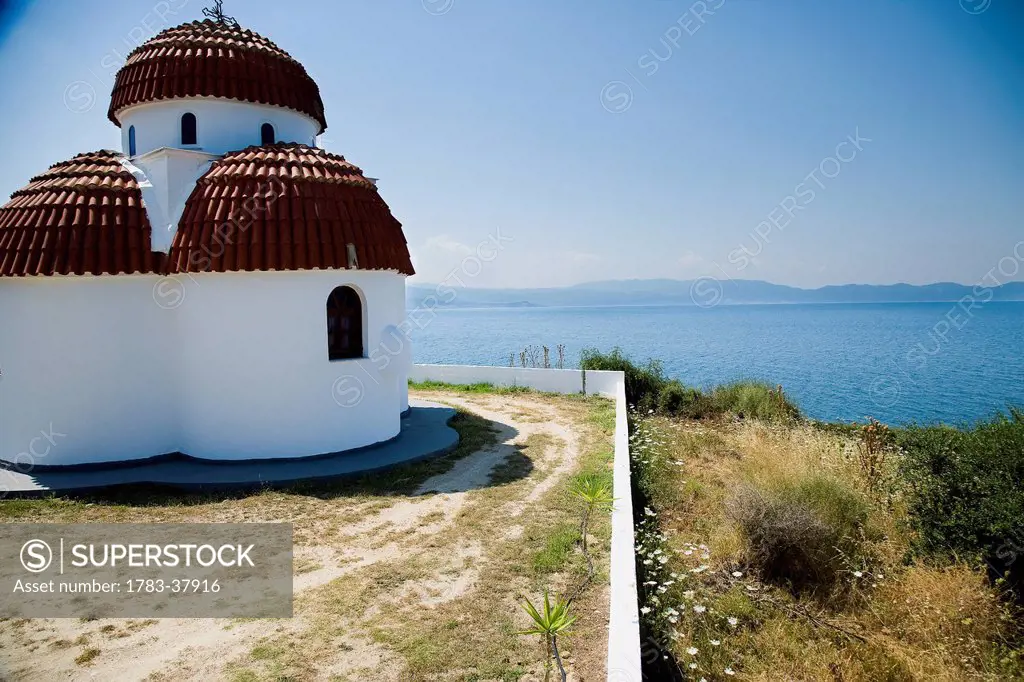Whitewashed Greek Orthodox church overlooking Mediterranean sea; Nea Roda, Halkidiki, Greece