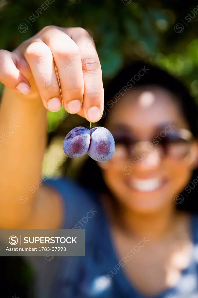 Young woman showing pink grapes; Ierissos, Halkidiki, Greece
