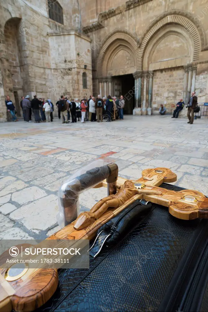 Large wooden crucifix on suitcase in courtyard of Holy Sepulcher; Old City, Jerusalem, Israel