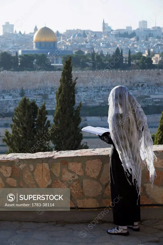 Pilgrim praying on Mount of Olives facing Old City; Jerusalem, Israel