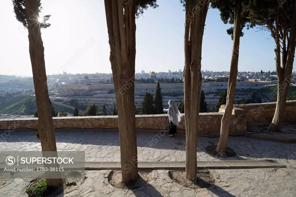 Pilgrim praying on Mount of Olives facing Old City; Jerusalem, Israel