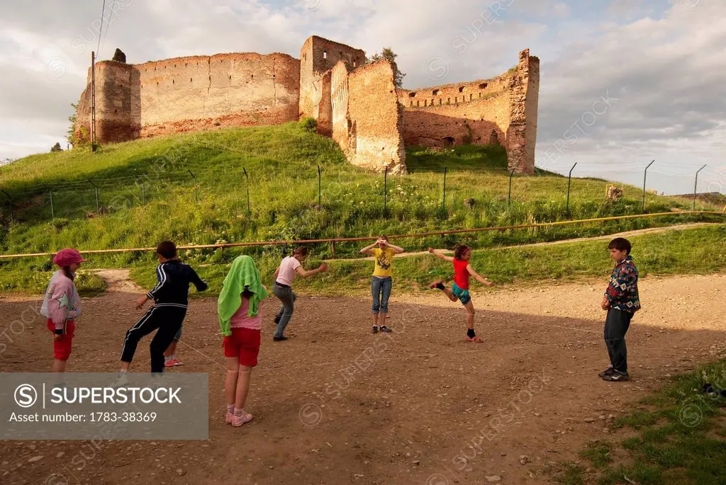 Kids playing near old ruin; Slimnic, Romania