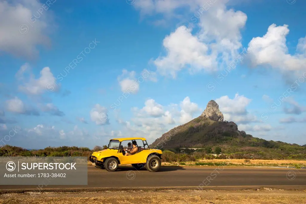 Yellow car and Morro do Pico in background; Fernando de Noronha, Pernambuco, Brazil