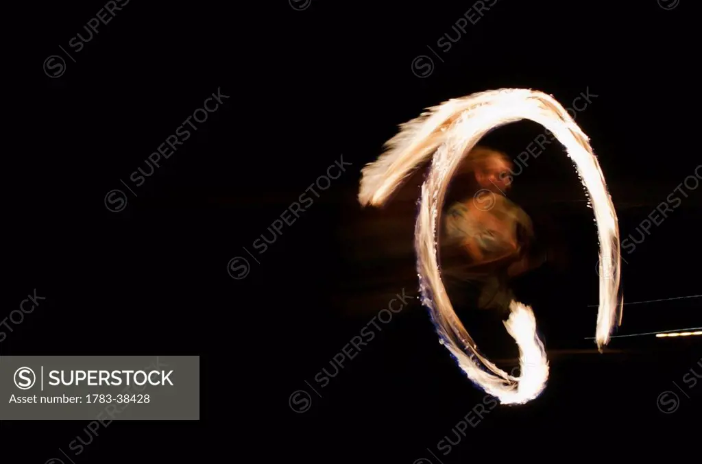 Man juggling fire at night; Reading, Berkshire, UK