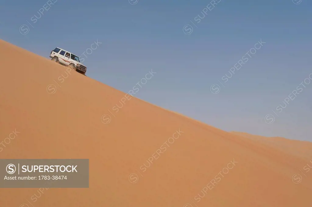 Four wheel drive going down steep sand dune; Liwa, Abu Dhabi, UAE