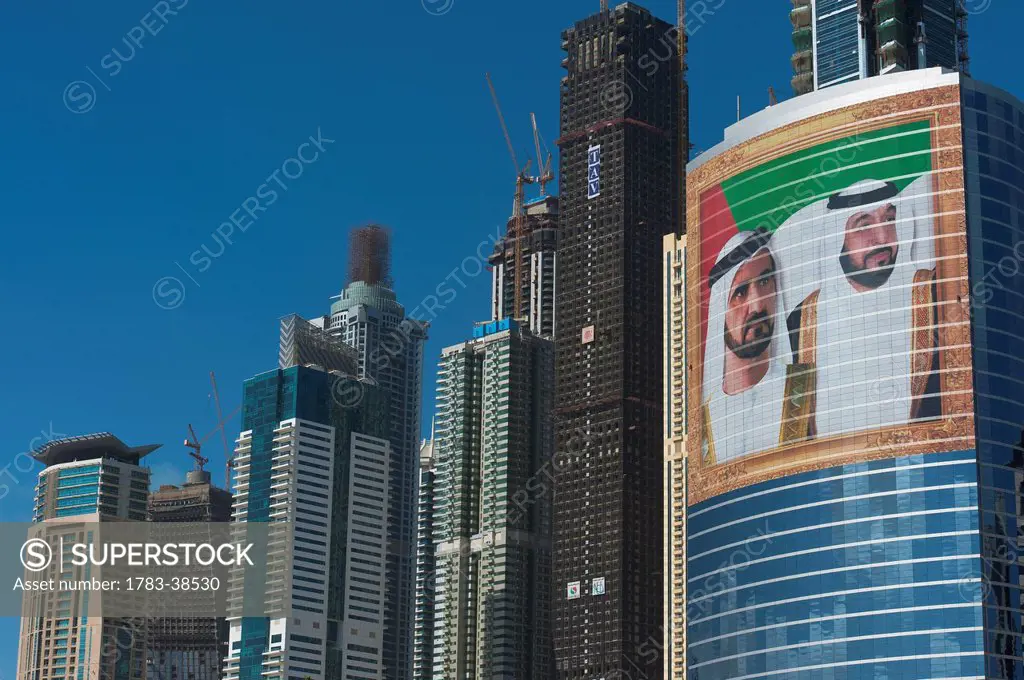 Large portrait of Sheikh Mohammed Bin Rashid Al Maktoum and Khalifa bin Zayed Al Nahyan on office building; Dubai, UAE