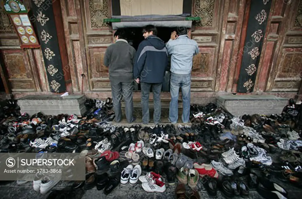 Hundreds of pairs of shoes lie outside the prayer hall during Friday prayers at the Great Mosque, Xian, Xi'an, Capital of Shaanxi Province, China 