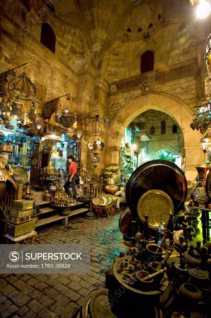 Woman shopping at night at stalls in covered gateway in Khan El Khalili; Cairo, Egypt