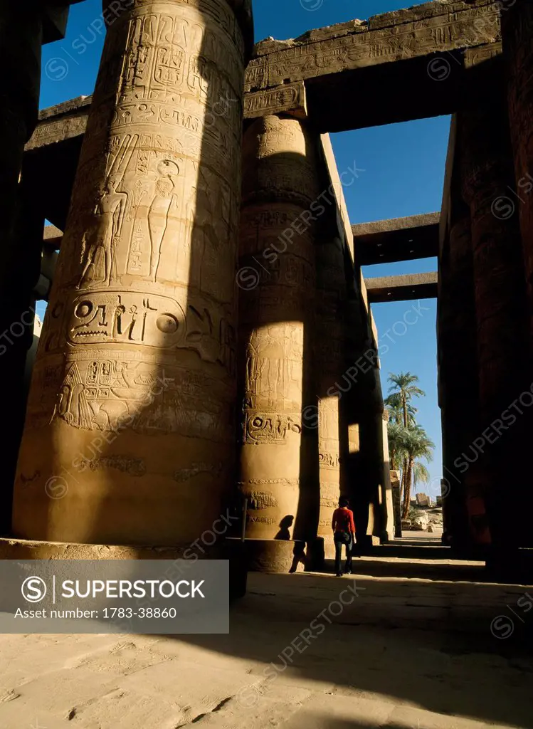 Woman walking through Great Hypostyle Hall of Temple of Amun or Karnak; Luxor, Egypt