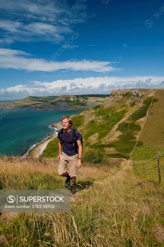 Walker going up stairs up to St Aldhelm's Head on South West Coastal Path; Purbeck, Dorset, UK