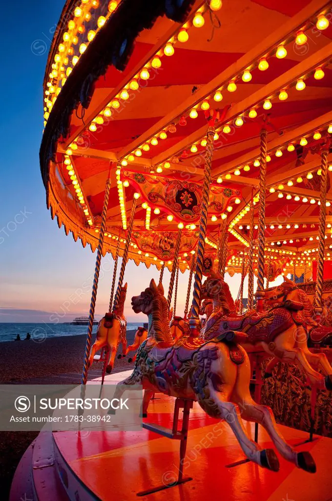 Merry-go-round on Brighton beach at dusk; East Sussex, UK