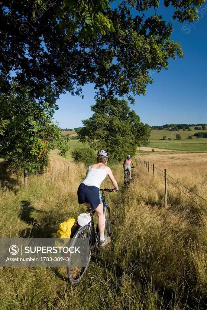 Two women cycling down bridleway near Winchelsea; East Sussex, UK