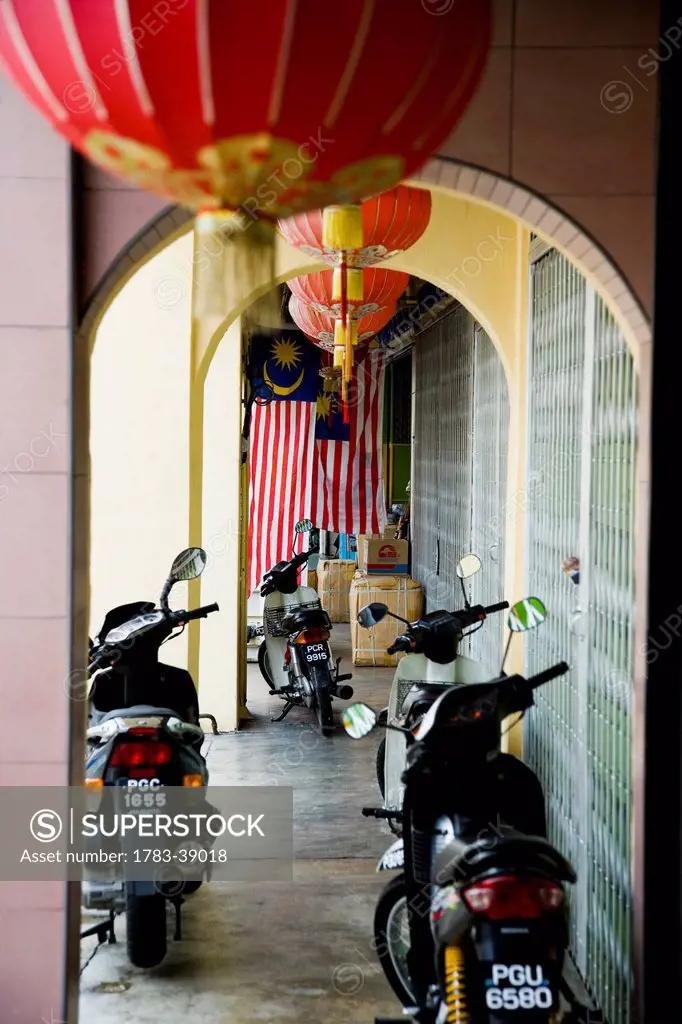 Archway over long corridor with scooters parked along side; Georgetown, Pulau Pinang (Penang), Malaysia