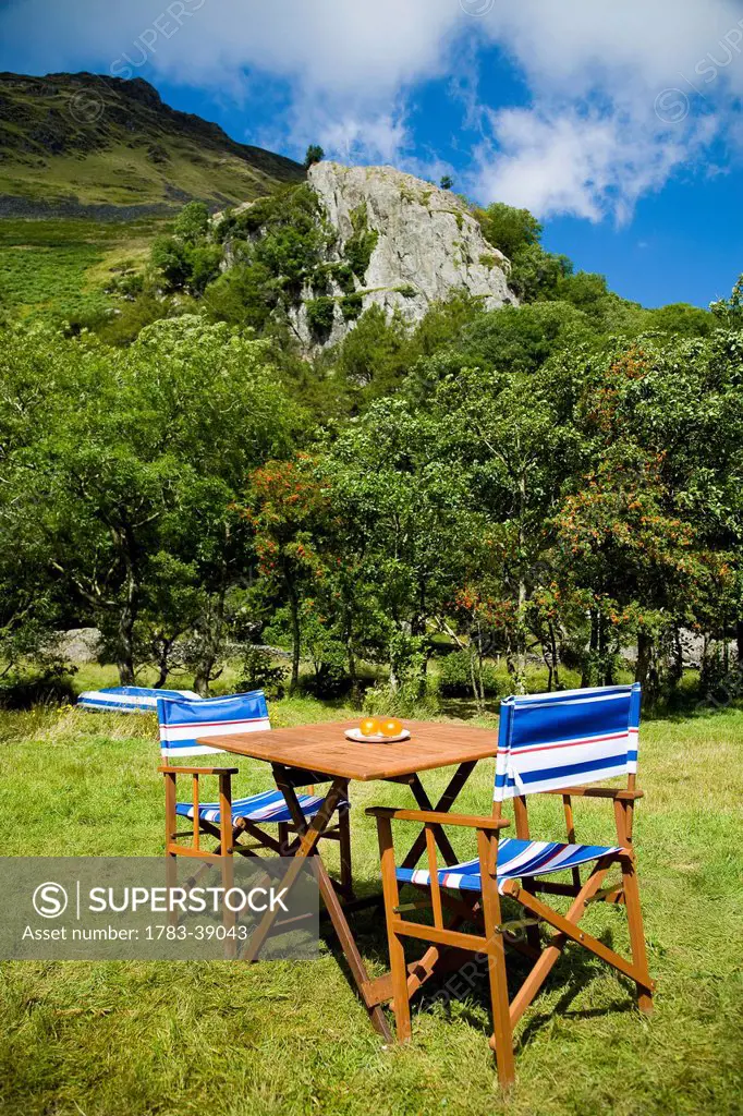 Table and chairs laid out at Llyn Gwynant Campsite; Nant Ggwynant, Snowdonia National Park, North Wales, Wales, UK