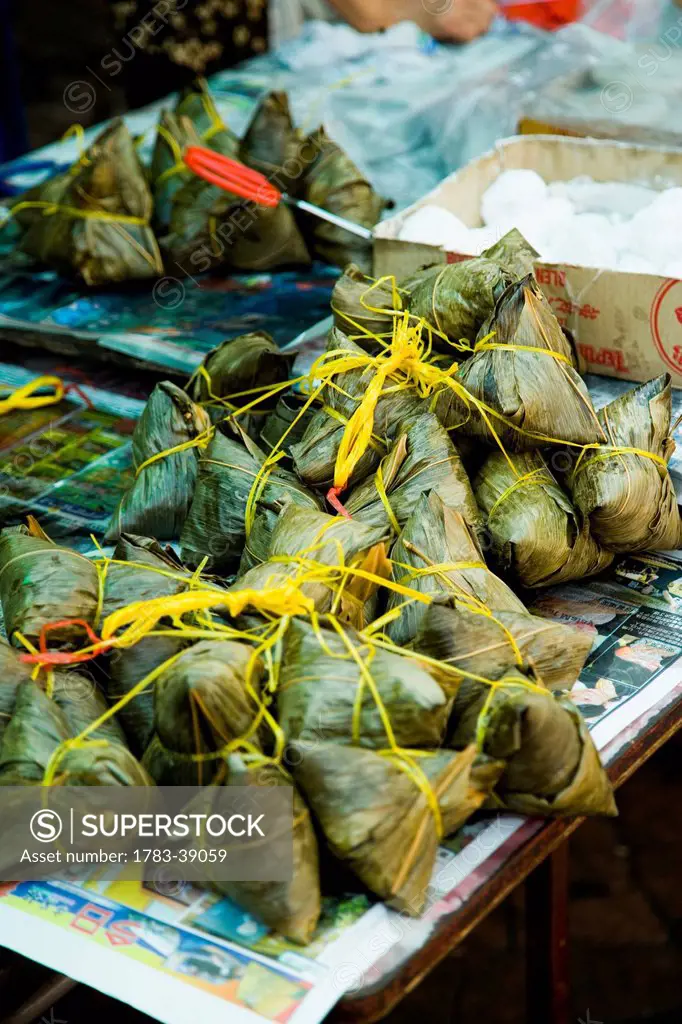 Nasi Lemak, coconut rice parcels, wrapped in banana leaves, on market stall table at Jalan Petaling (Petaling Street) in Chinatown; Kuala Lumpur, Mala...