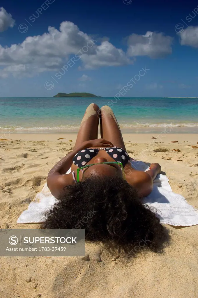 Pretty woman wearing swimsuit sunbathing on Paradise Beach; Carriacou Island, Grenadines, Grenada, Caribbean