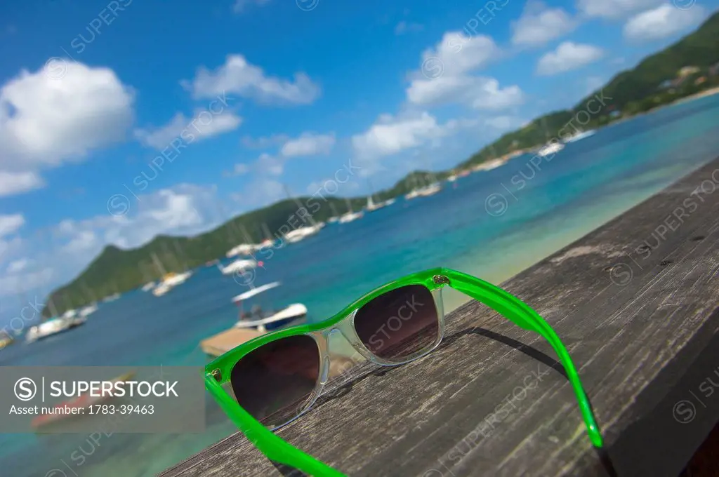 Sunglasses with Tyrell Bay in background; Carriacou Island, Grenadines, Grenada, Caribbean