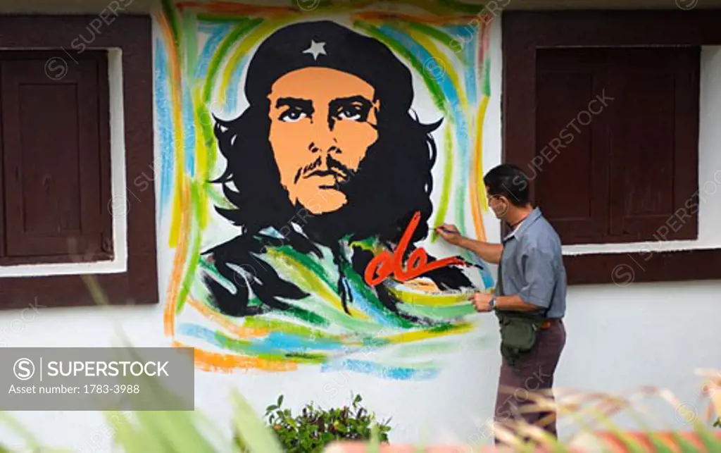 Local artist painting wall mural of Che Guevara, Cuba