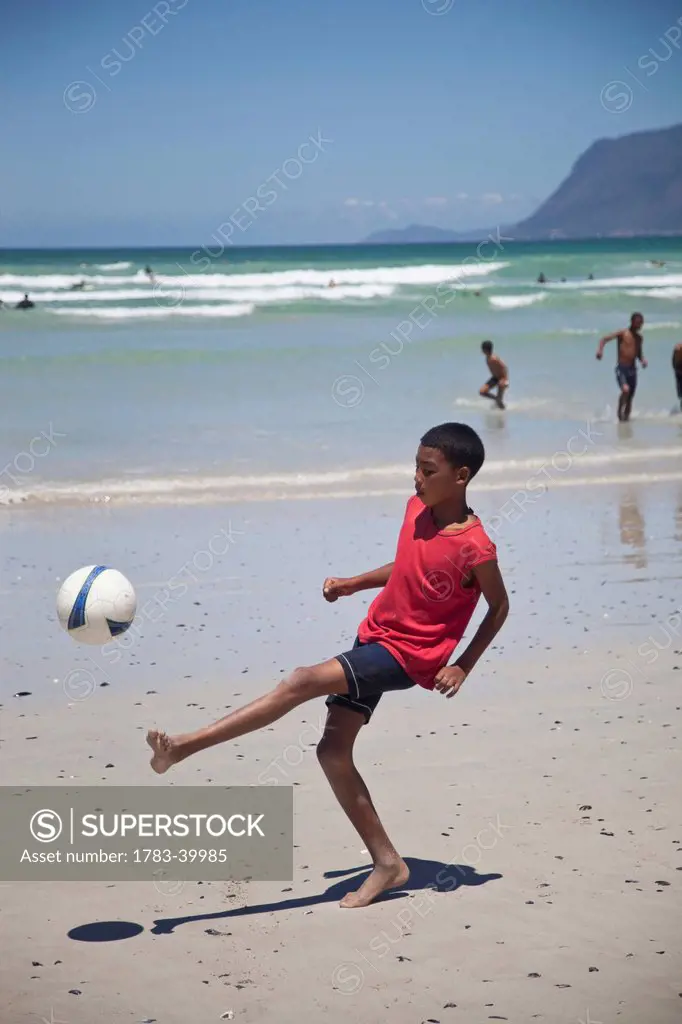 South Africa, Muizenberg; Cape Town, Local boys playing football on beach