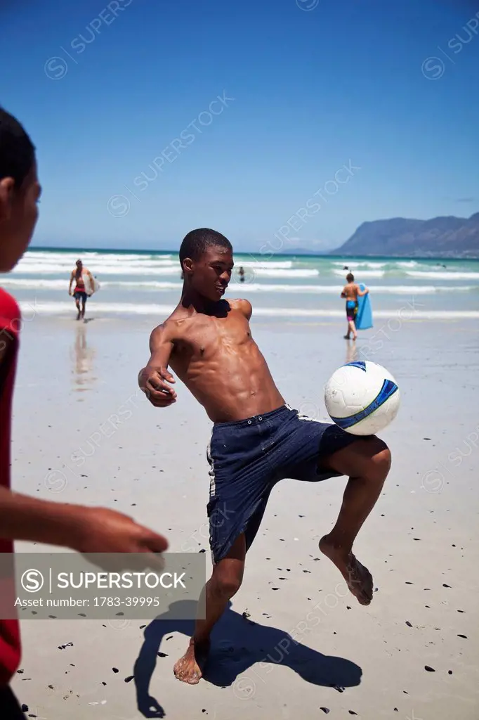South Africa, Muizenberg; Cape Town, Local boys playing football on beach