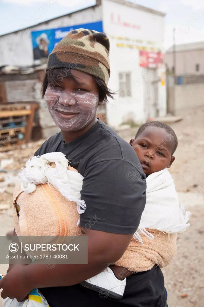 South Africa, Garden Route, Port Elizabeth, Portrait of woman carrying her son; New Brighton