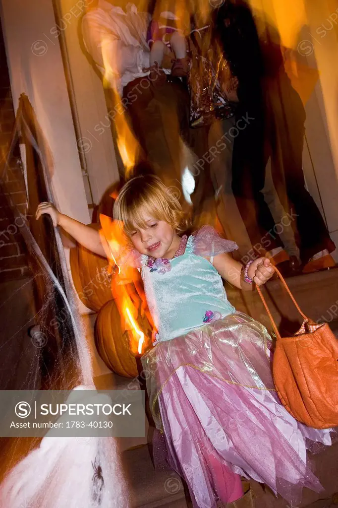 USA, New York State, Girl in Halloween costume walking down stairs; New York City