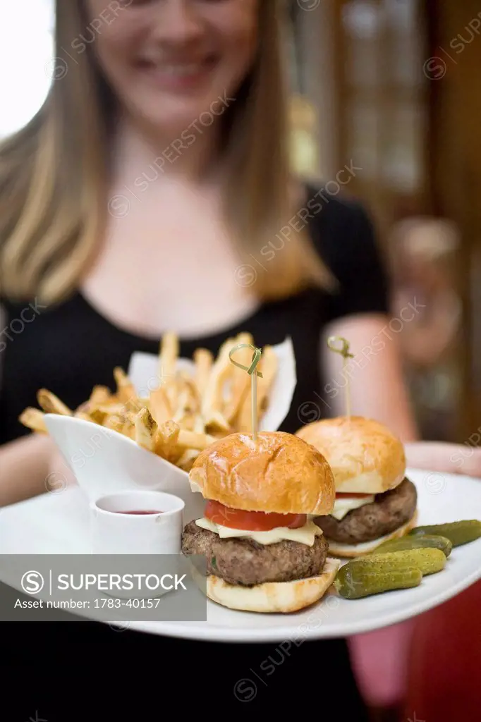 USA, New York State, Waitress with fries and hamburger in Cinema Restaurant; New York City