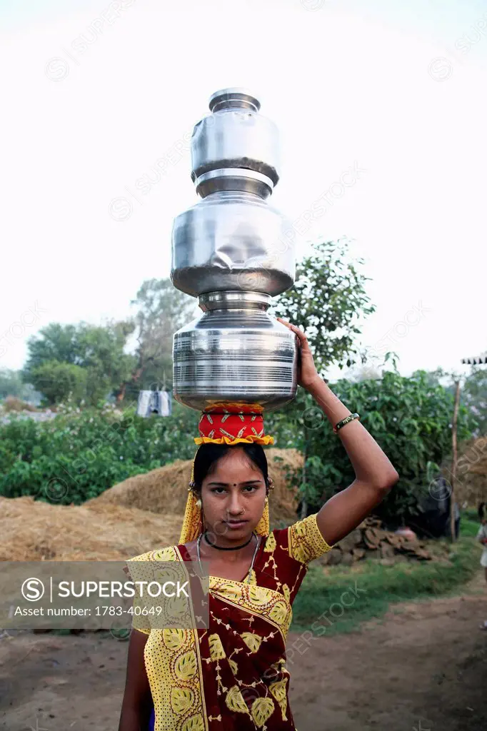 India, Gujurat State, Girl holding milk pots on head; Ahmedabad City