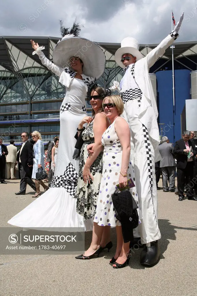UK, England, Performers on stilts at entrance to Grand Enclosure during Royal Ascot horse racing meeting; Berkshire