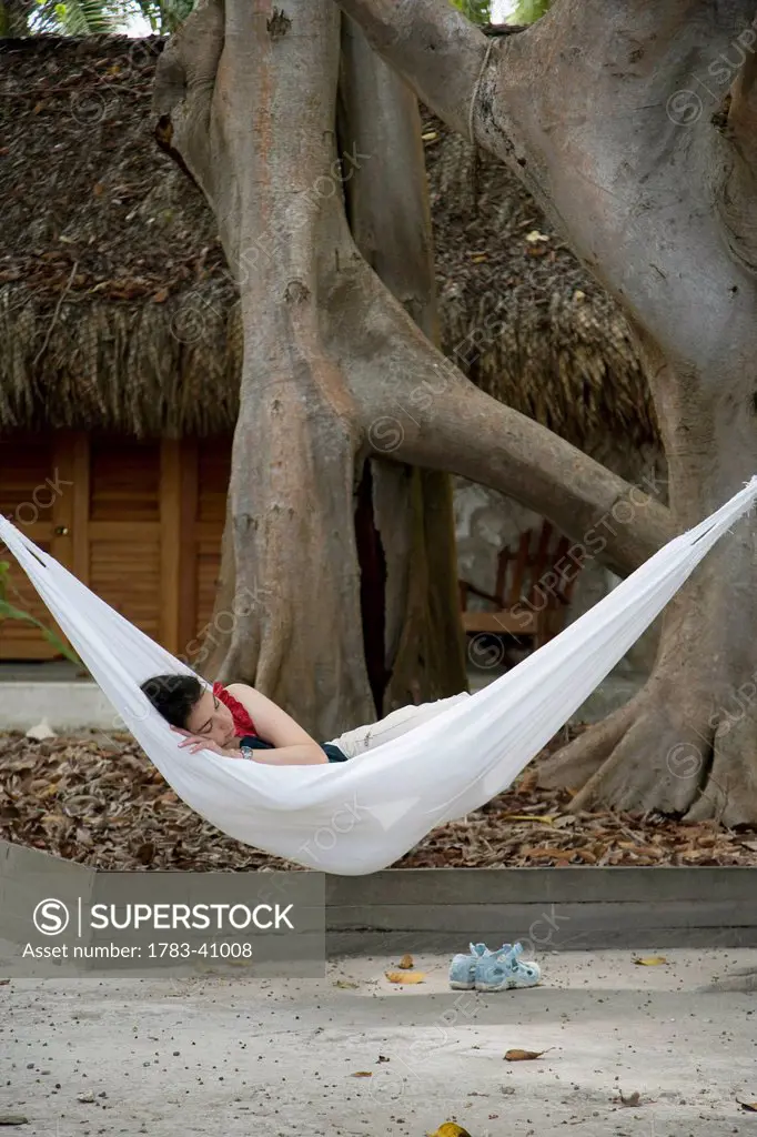 Colombia, Cartagena, Person relaxing in hammock; Islas del Rosario
