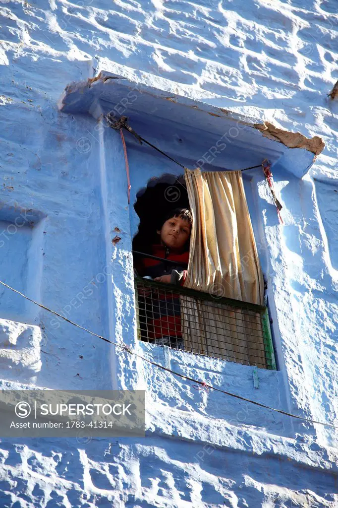 Boy looking out of a window in Blue Town of Jodphur Rajasthan India © Andy Kerry / Axiom