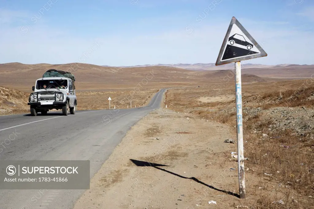 Jeep and road sign on road between Ulaanbaatar and Karkhorin; Mongolia