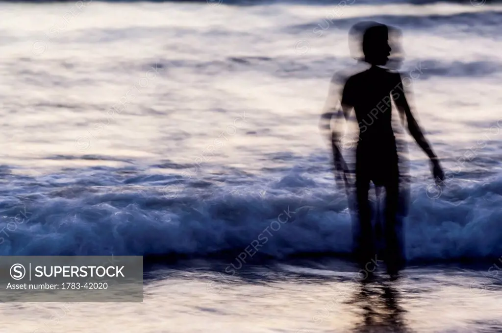 India, Karnataka, Blurry picture of silhouette and waves; Gokarna