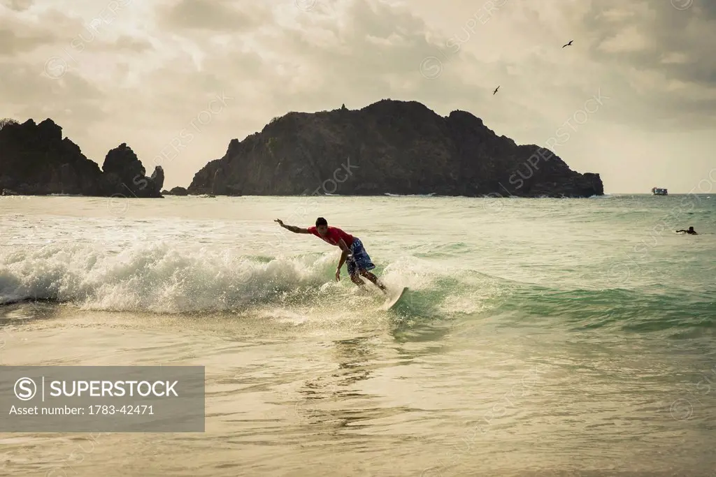 Surfing in Praia da Cachorro, Unesco World Heritage Site; Fernando de Noronha, Pernambuco, Brazil