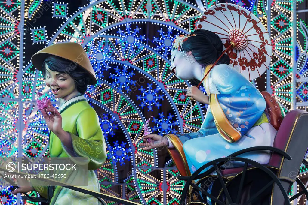 Detail of large Falla of Japanese lady being pulled on rickshaw by man displayed on street as part of Fallas Festival; Valencia, Spain