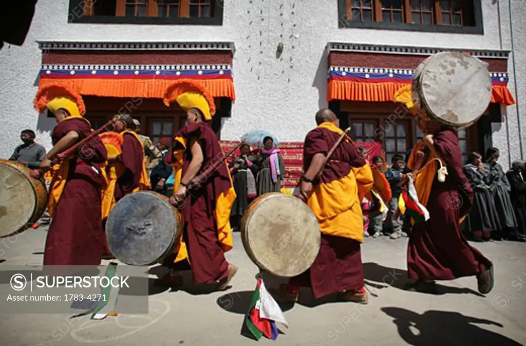 Nuns / monks in traditional dress with yellow orange hats and robes at 800 year old birthday celebration / rituals of the Buddhist Drukpa Lineage, Naro Photang Shey, (Shey Monastery), Leh Ladakh, Indian Himalayas, India