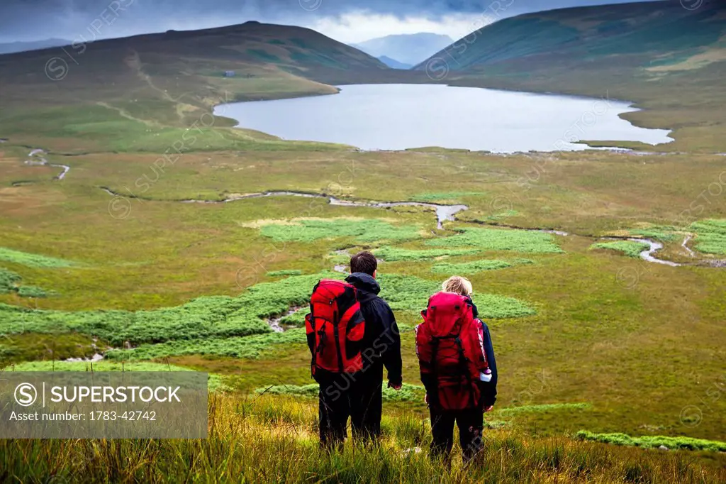 Hikers with Burnmoor Tarn; Western Lake District, Cumbria, England, UK