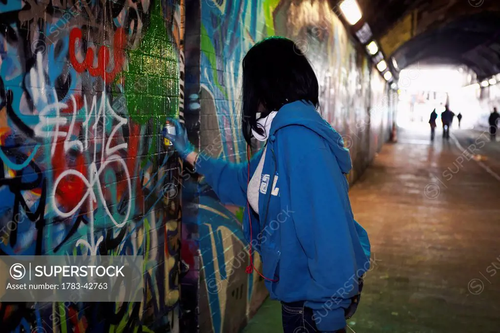 Woman tagger at Leake Street, Graffiti Tunnel; Lambeth, London, England, UK